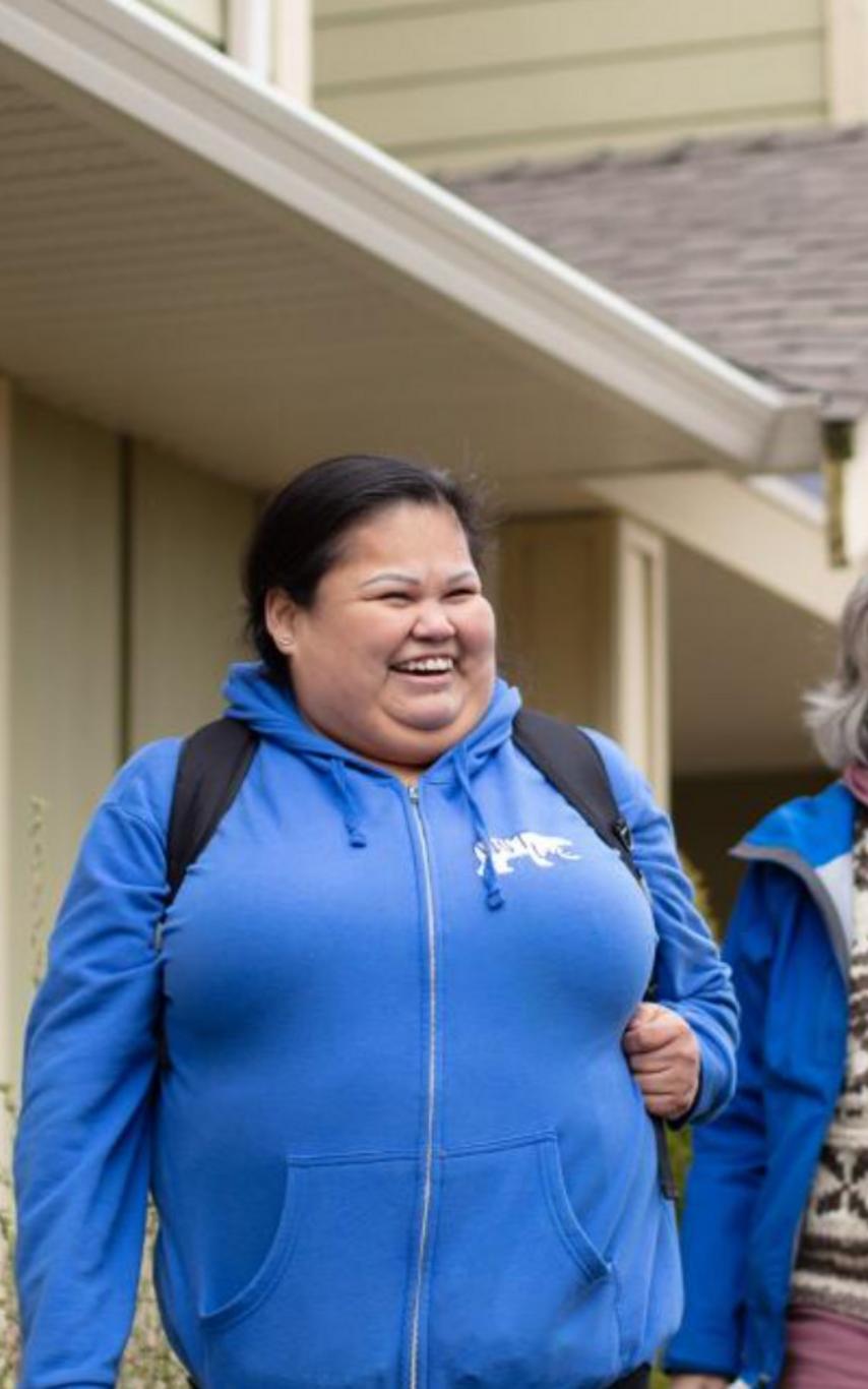 Happy people outside in front of housing.